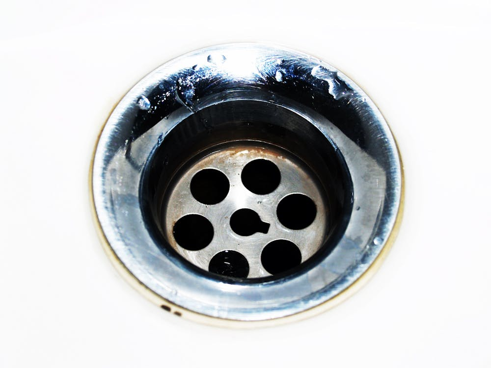 A close-up of a sink drainage hole after unclogging